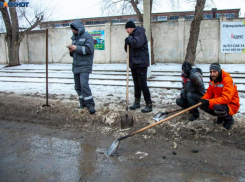 Коммунальщики в Волжском вручную очищают прилотковую часть дороги