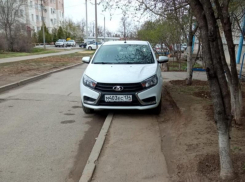 Машина «ЯндексТакси» паркуется на тротуаре в одном из дворов Волжского