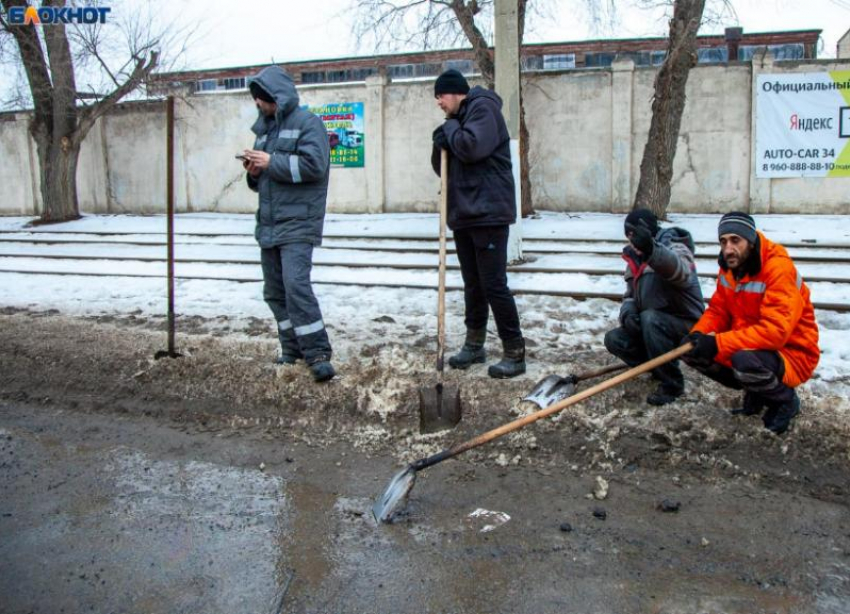 Коммунальщики в Волжском вручную очищают прилотковую часть дороги